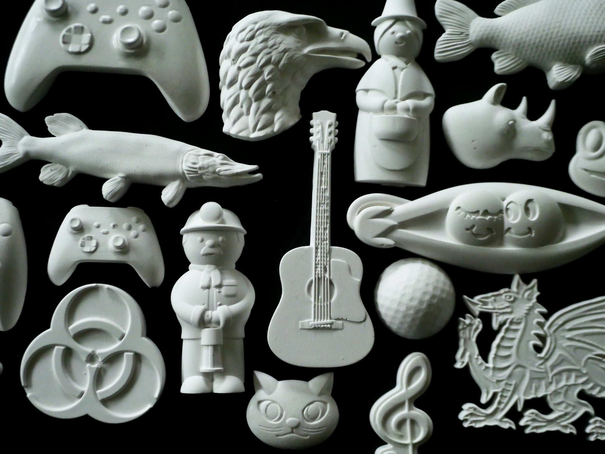 Collection of various white ceramic sculptures on a black background