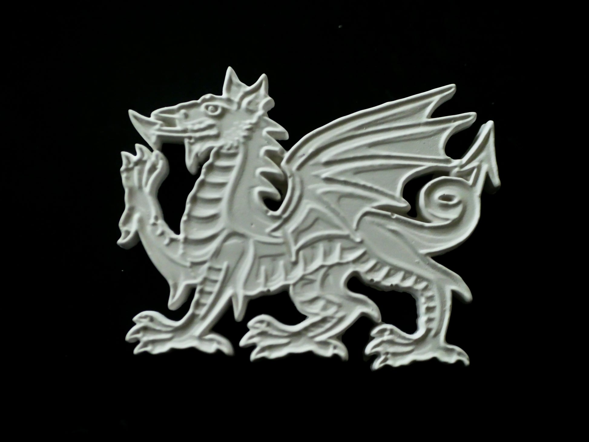 Decorative Welsh dragon emblem on a black background