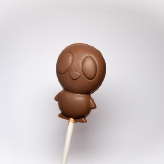 A chocolate lollipop with a design resembling an baby chick, presented on a stick.