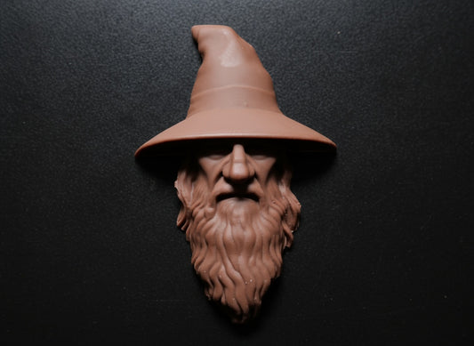 Chocolate sculpture of a wizard's head with a pointed hat on a dark background