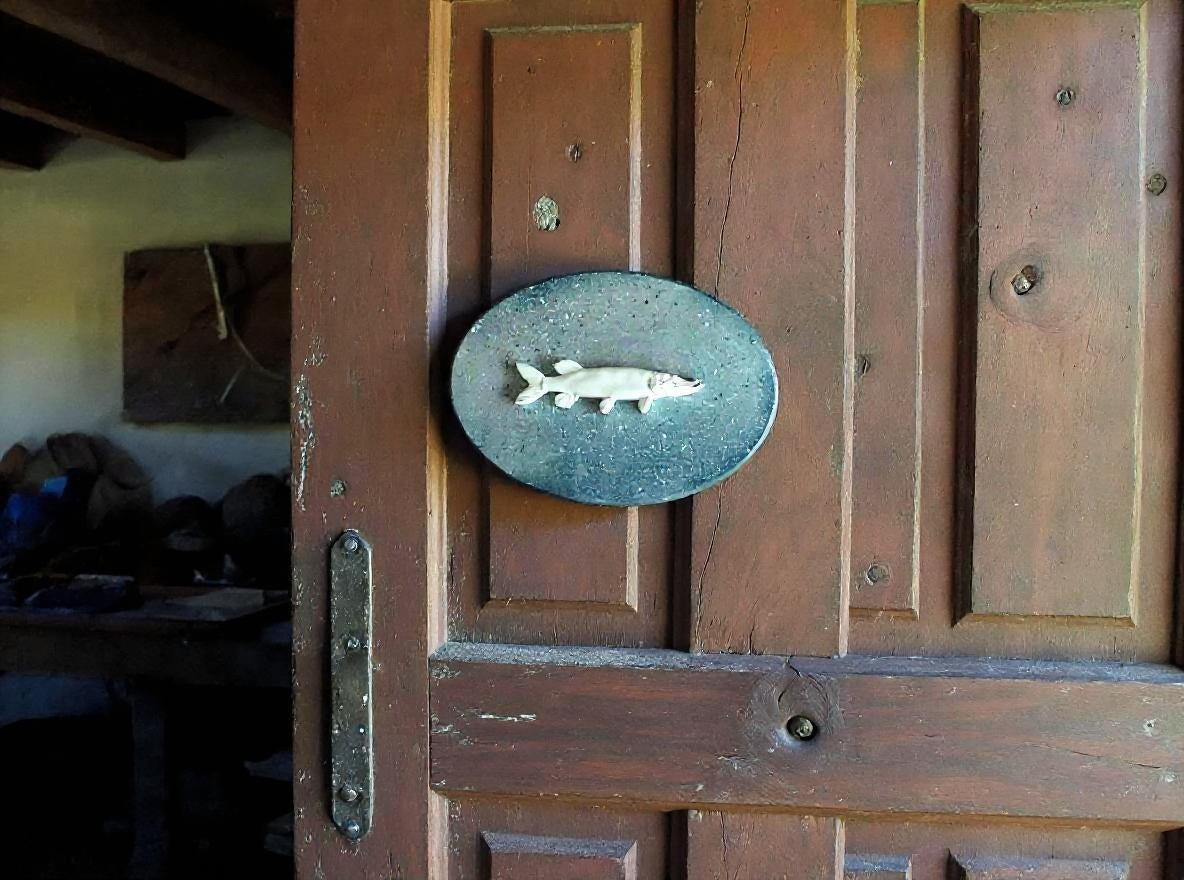 Wooden door with a decorative fish emblem