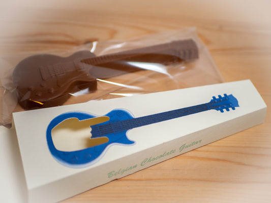 A guitar made out of chocolate next to a gift box.