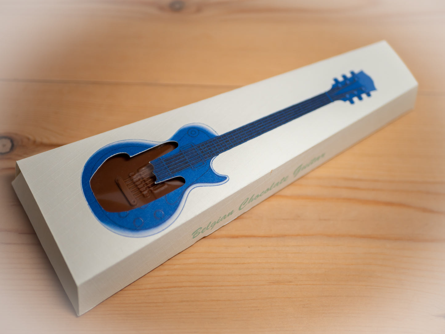 A guitar shaped chocolate inside a gift box.