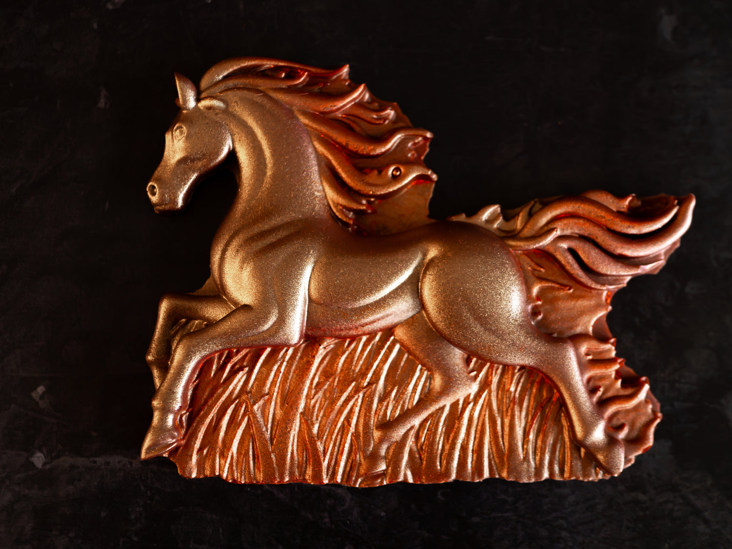 Decorative painted chocolate fire horse against a dark background