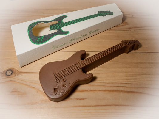 An edible chocolate guitar next to a gift box.