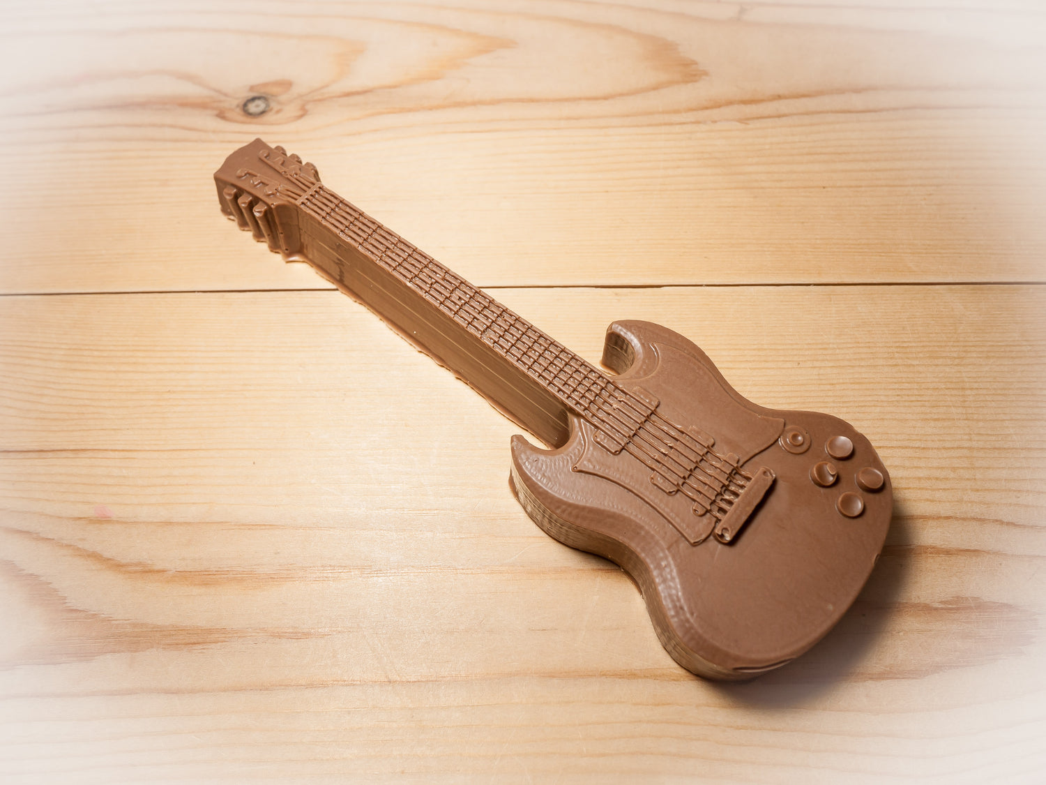 A Gibson SG guitar made out of chocolate.